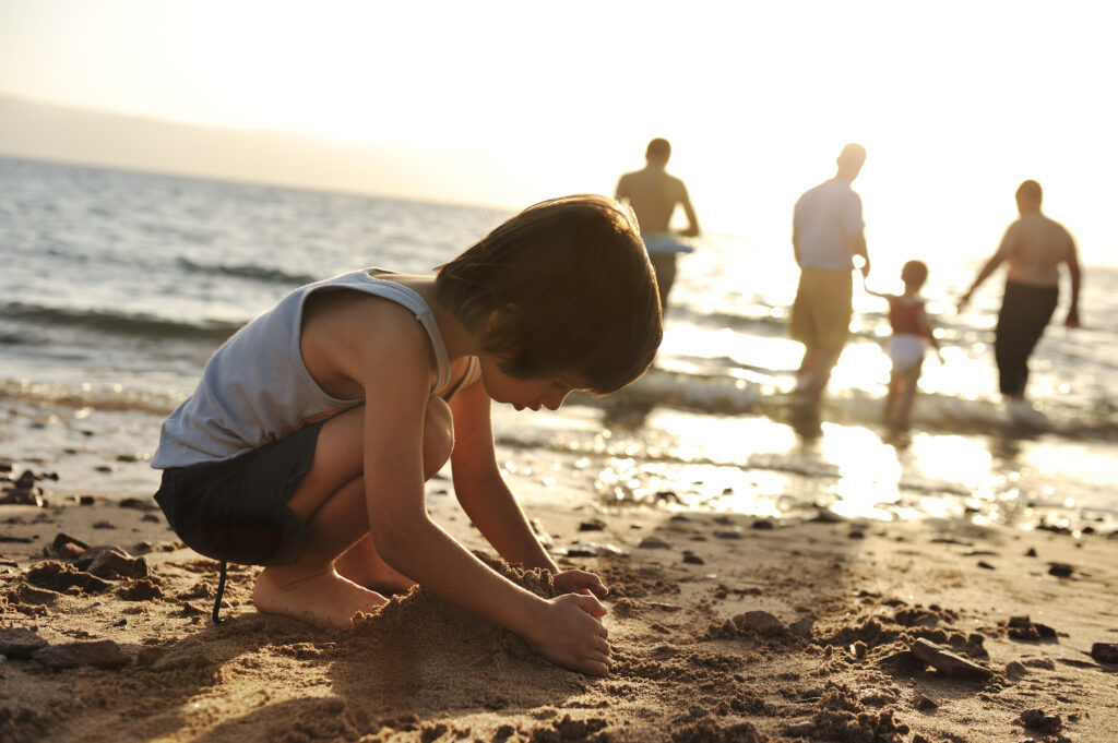 image of boy playing alone in the sand